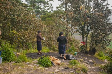 Maya bölgesinden genç bir adam tipik kıyafetleriyle Cajola ormanında çöp topluyor.