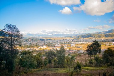 Vadide gün batımında evleri ve ağaçları olan bir şehir.