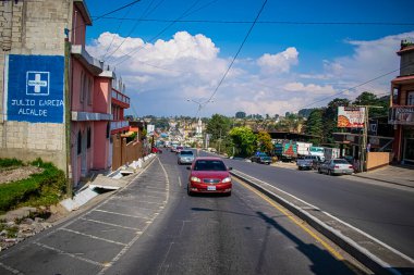 Kırmızı arabası ve güzel manzarası olan San Juan Ostuncalco Yolu