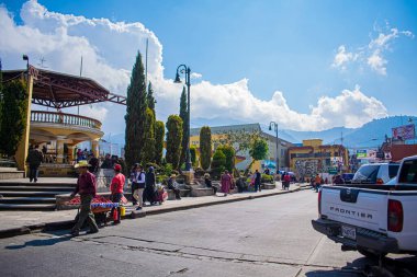 San Juan Ostuncalco 'da tipik kıyafetlerle yürüyen insanlarla dolu bir park.