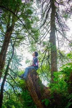 Mavi gökyüzü geçmişiyle profilde oturan sakallı adam siyah kıyafetler giyiyor, San Juan Ostulcalco Quetzaltenango