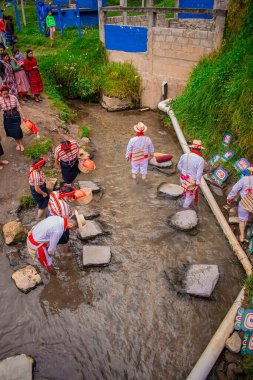 Kadınlar ve erkekler nehirde tipik bir kostümle yürüyor.