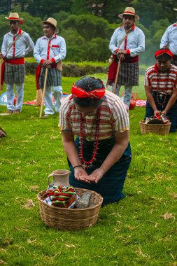 Tipik Rpoa Maya anne sepetiyle yeşil çimlerde diz çökmüş bir kadın.
