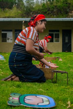 Tipik Maya elbiseli kadın sepetini dramatize ediyor.