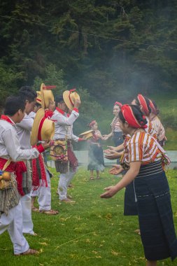Yerli kadınlar ve erkekler geleneksel olarak tipik kıyafetlerle dans ederler.