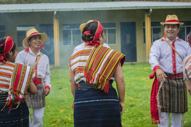 Erkekler dans ediyor ve kadınlar Maya yerlisi elbiseleriyle