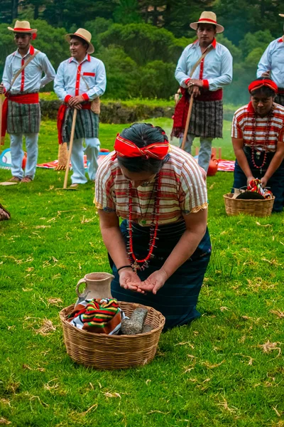 Tipik Rpoa Maya anne sepetiyle yeşil çimlerde diz çökmüş bir kadın.