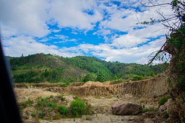Dağları, bulutları ve mavi gökyüzü olan güzel tepeler