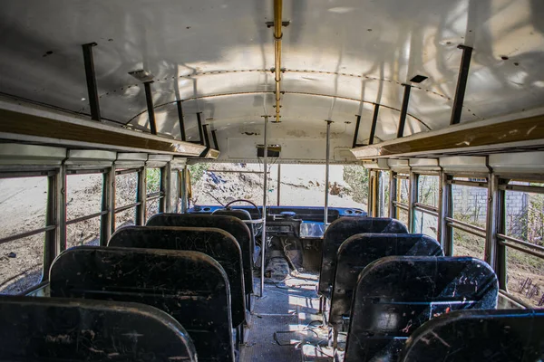 interior of bus with worn black chairs