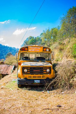 Sarı otobüs ızgarayla sokağa park edilmiş.