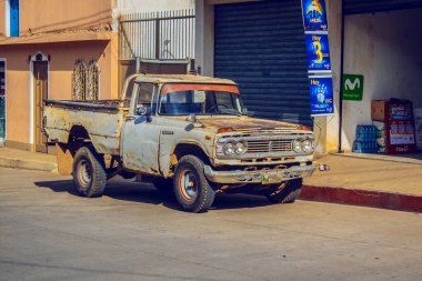 Kaporta işi yapan beyaz bir araç, bazı evlerin önüne park etmiş bir motor.