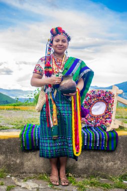 Arkada güzel dağlar, Maya hanımı bir resim için poz veriyor.