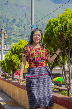 Arka planda bir fotoğraf için poz veren genç bayan güzel bir ağaç dağı.