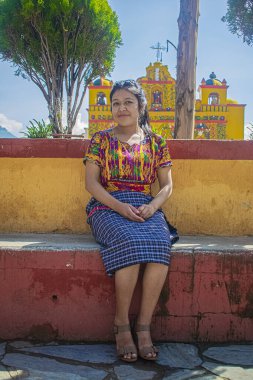 Oturan kadın kilisenin önünde poz veriyor.