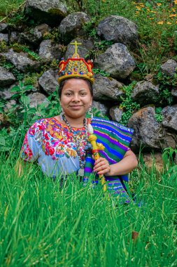 Tipik Maya kostümlü kadın, fotoğrafa poz veriyor, arka planda onu çevreleyen güzel manzara ve doğa.