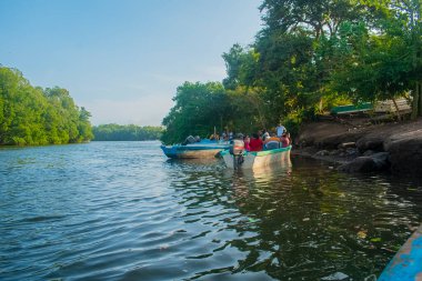 Sahilin kıyısında insanlar bir teknede Paceo 'nun tadını çıkarıyorlar.