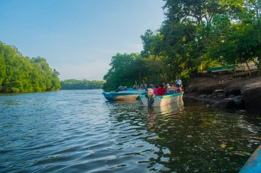 Sahilde bir teknedeki insanlar