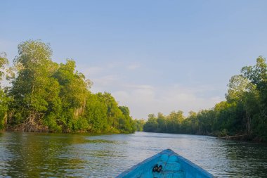 Beautiful summer sunset bluish sky, flared clouds waves boats, trees around sea and sand