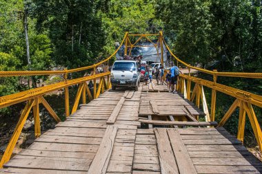 Tahta köprü ve semuc champey 'de insanlar yürüyor.