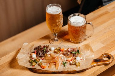 Masada bir bardak bira, mezenin yanında.