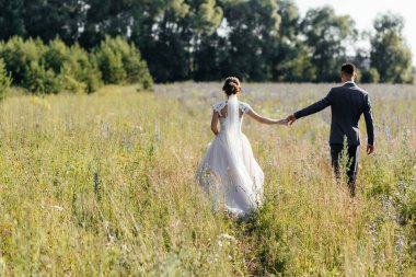 Gelin ve damat tarlada yürür ve el ele tutuşurlar