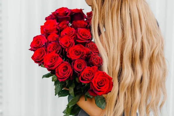 Bouquet of red roses in the hands of blonde — Stock Photo, Image