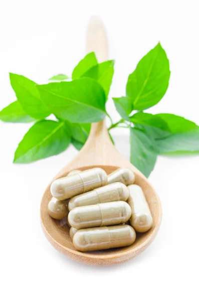 Herbal medicine capsules in wooden spoon. — Stock Photo, Image