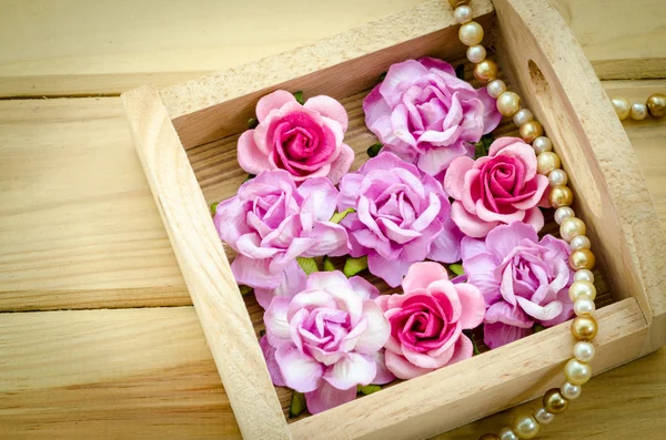 Vintage rosa Rose und Perlenkette auf Holzhintergrund. — Stockfoto
