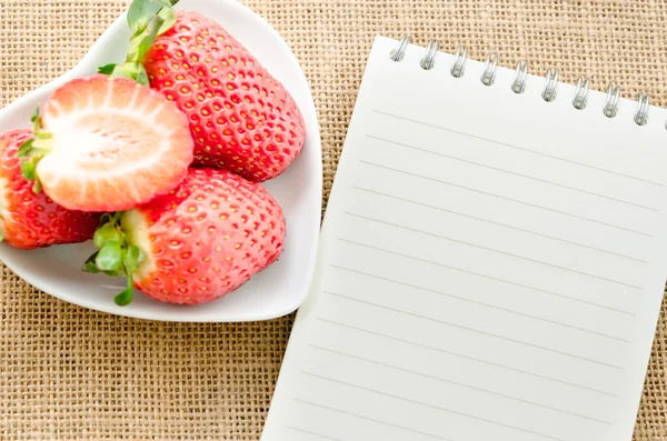 Journal en papier blanc avec fraises fraîches . — Photo