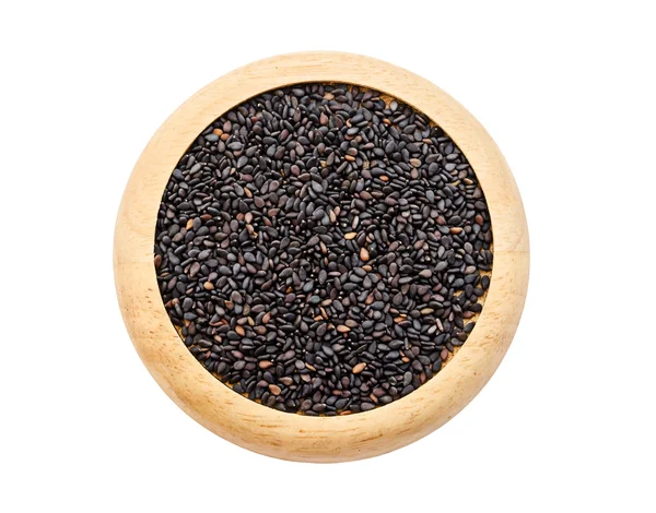 Montón de semillas de sésamo negro en plato de madera . — Foto de Stock