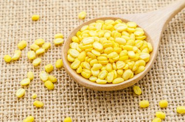 soyulmuş split mung fasulye bir tahta kaşık içinde.