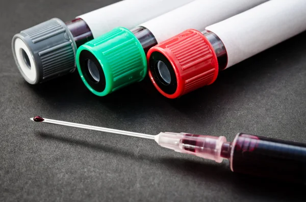 Échantillon de sang en tube pour analyse et seringue . — Photo