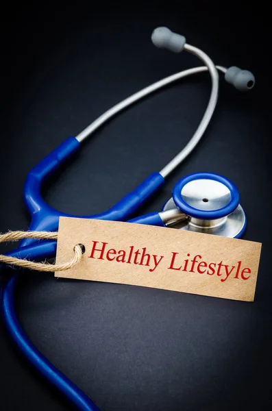 Gezondheid levensstijl woord in papier tag met de stethoscoop. — Stockfoto