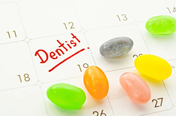 Dentista palavra no calendário com doces coloridos . — Fotografia de Stock