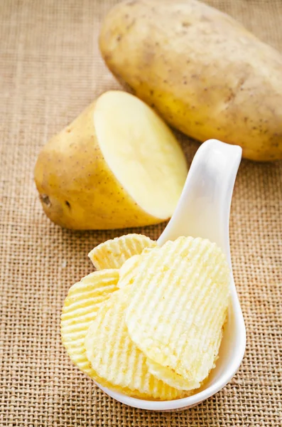 Chips and peeled potatos — Stock Photo, Image