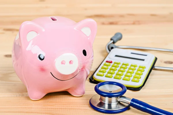 Piggy bank and stethoscope with calculator. — Stock Photo, Image