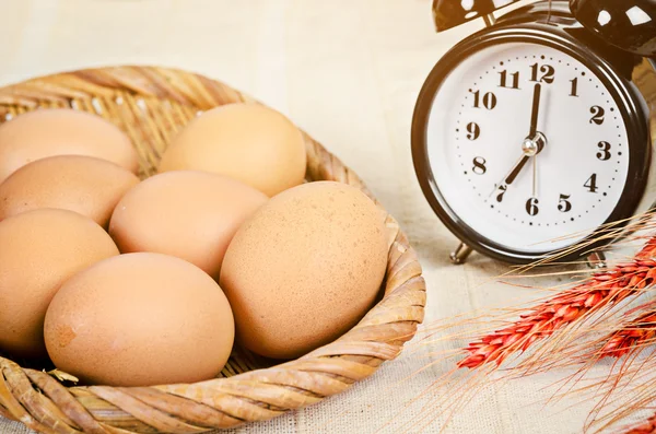 Świeże jaja i budzik. — Zdjęcie stockowe