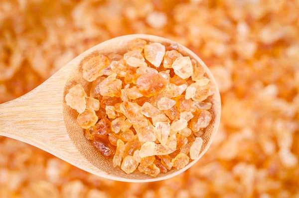 Healthy crystal sugar in wooden spoon.