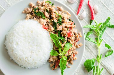 Kızarmış domuz pirzolası ve masa örtüsünde fesleğen..