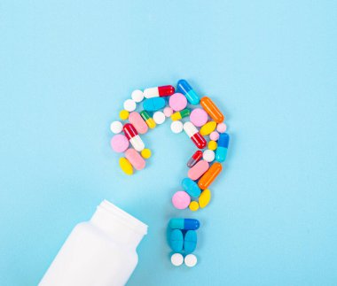 Mavi arka planda ilaç şişesi olan ilaçlardan kalma bir soru işareti..