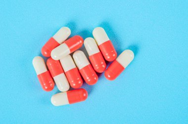 Mavi arka planda antibiyotik hapları kapsülleri.
