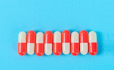 Mavi arka planda antibiyotik hapları kapsülleri.