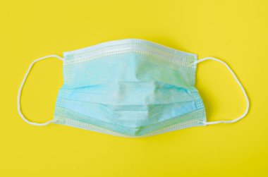 Mavi arka planda tıbbi tek kullanımlık yüz maskesi.