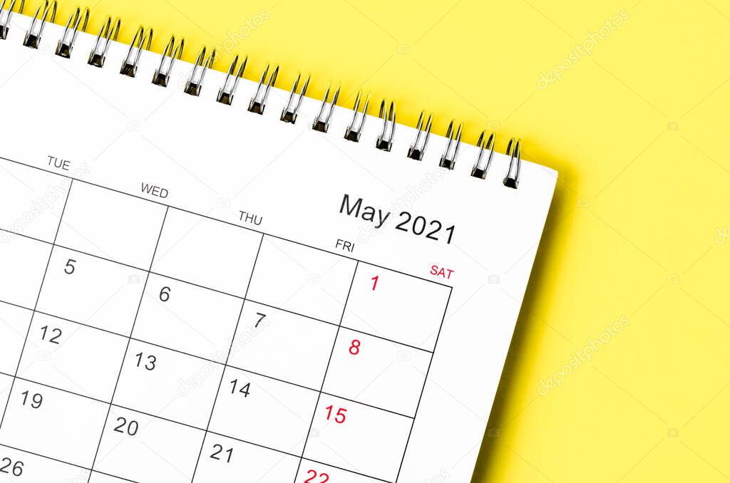 Close up May 2021 Calendar desk for organizer to plan and reminder on yellow table.
