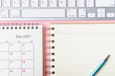 Pembe zemin üzerine not defteriyle Aralık 2021 takvimi.