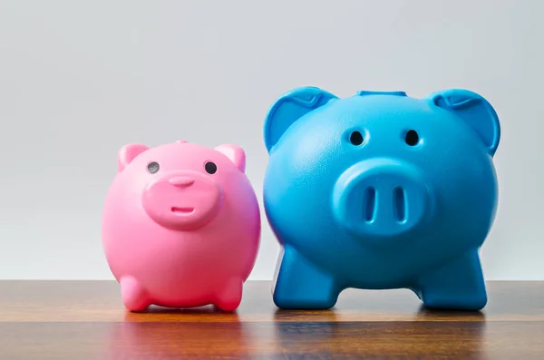 Pink and blue piggy bank on table background with empty space for your text or message.