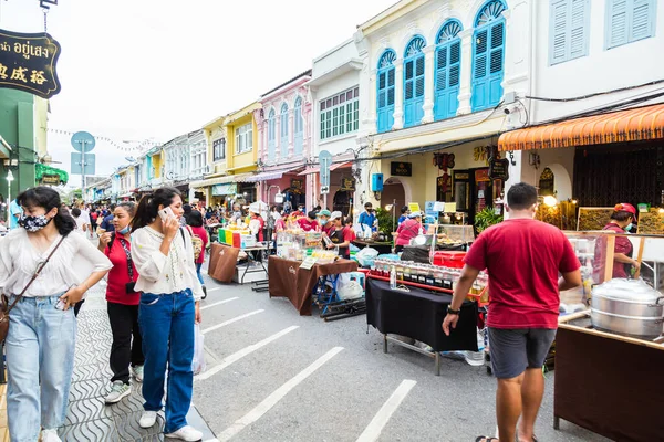 Phuket Town, Phuket, Tayland - 22 Kasım 2020. Phuket Walking Sreet, Phuket Old Town 'da bir gece pazarı. Alacakaranlıkta yerel halk ve turist kalabalığıyla sokak yiyecek pazarının manzarası.