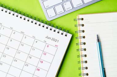 Yeşil arkaplan üzerine not defteri olan Haziran 2021 takvimi.