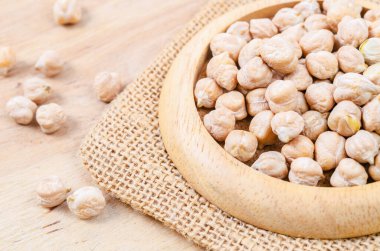 Ahşap arka planda pişmemiş nohutlar.