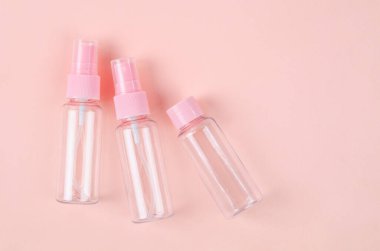 Pembe arka planda üç plastik temiz boş şişe..